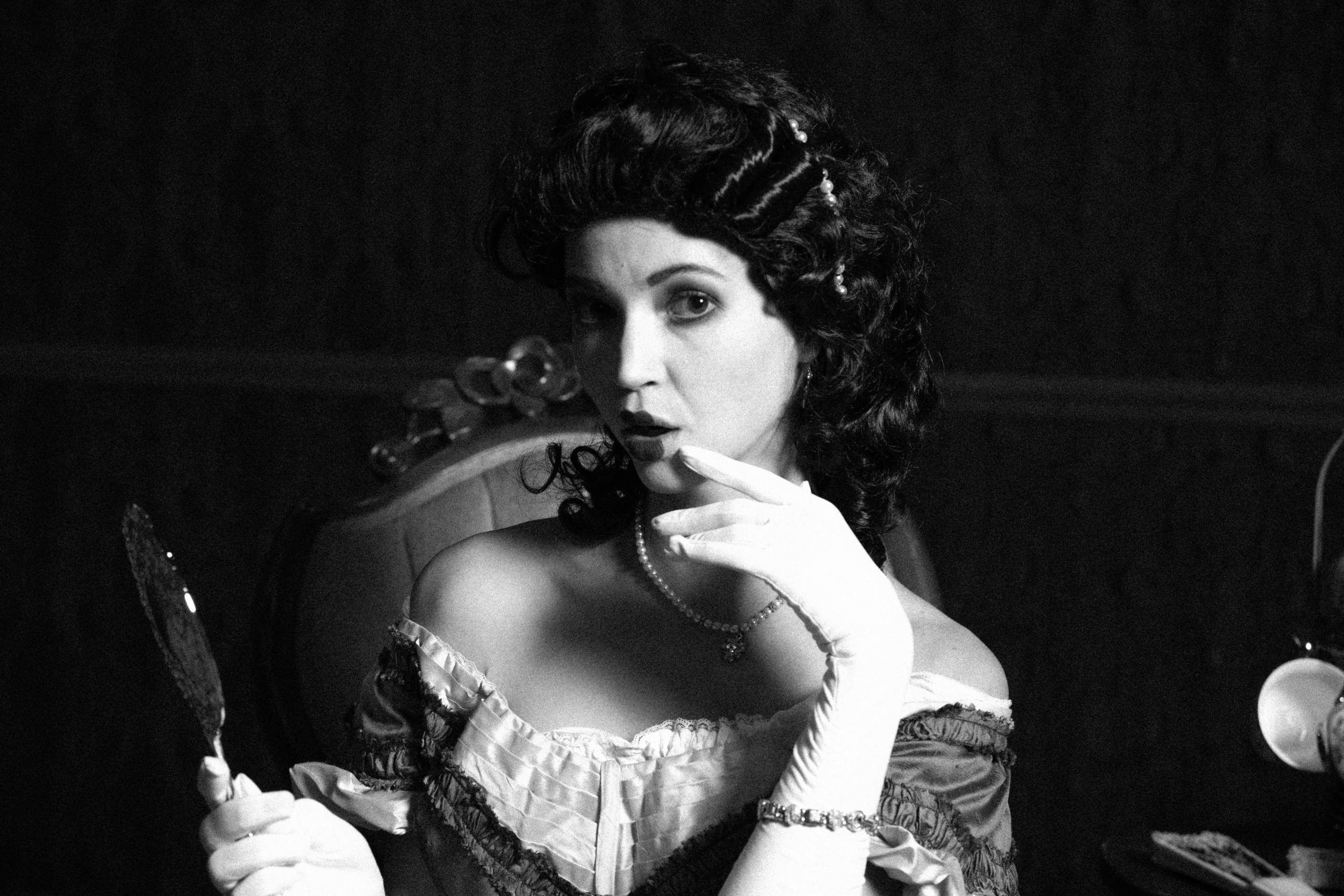 A timeless portrait in black and white, where soft light and shadow sculpt a moment of vintage elegance and quiet drama.