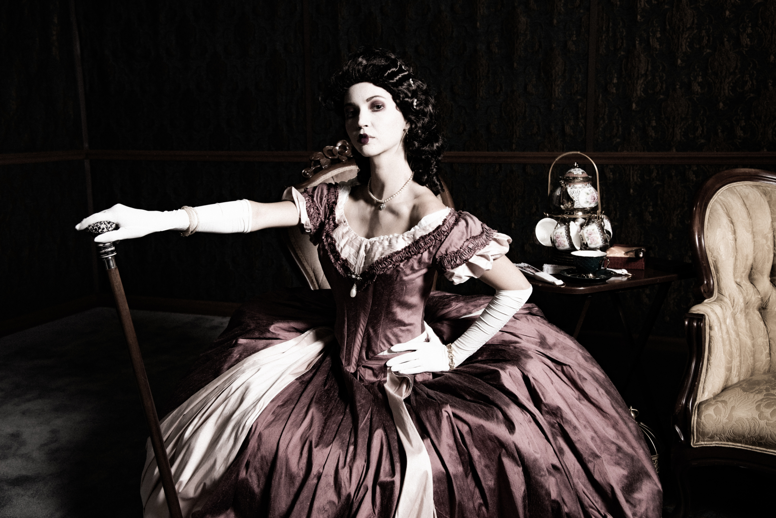 An elegant study in poise and period detail, where rich textures, dramatic light, and refined posture evoke the grandeur of another era.