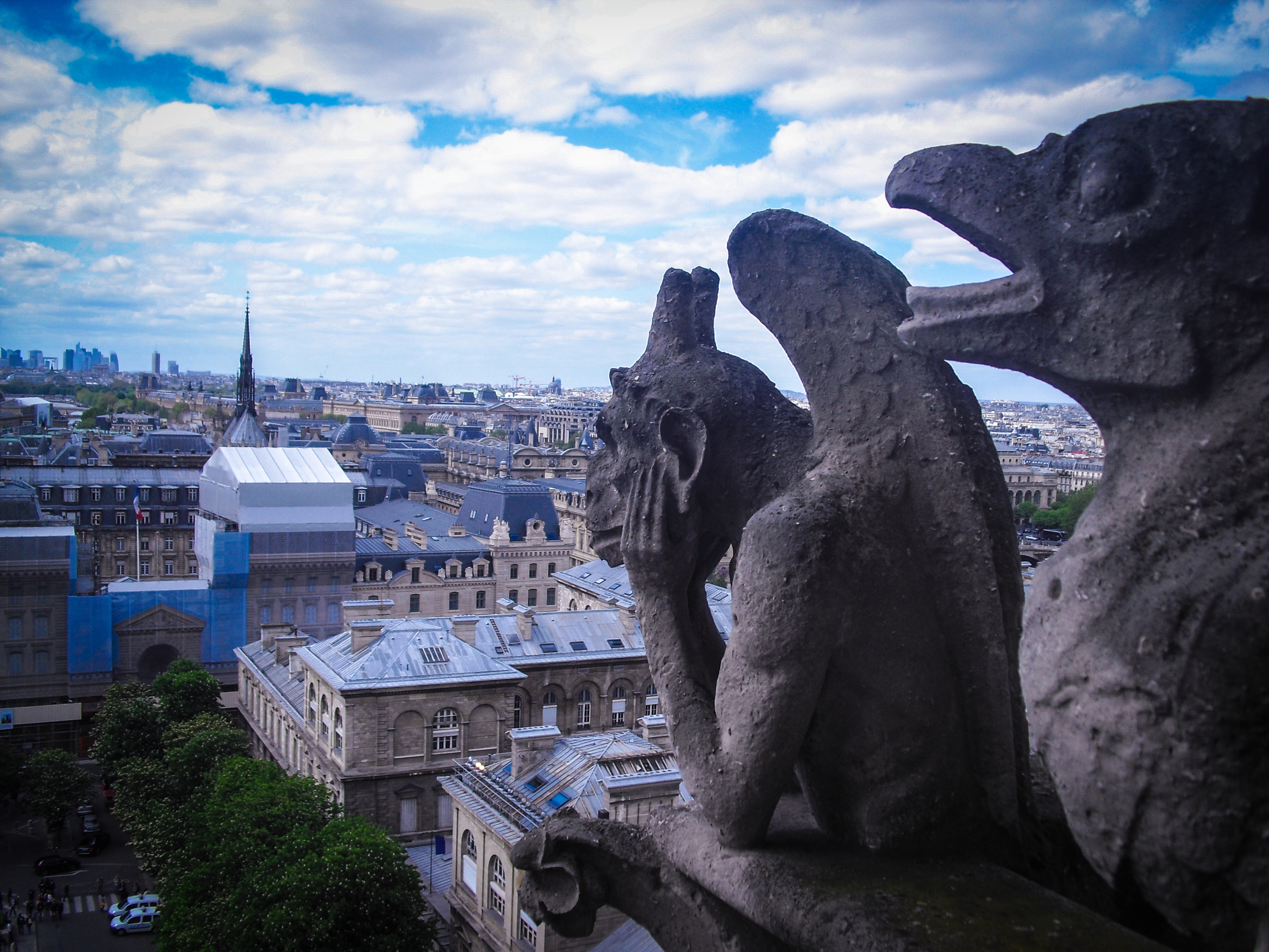 Perched high above the city, a silent stone guardian watches over sweeping rooftops and a skyline that stretches into the horizon.