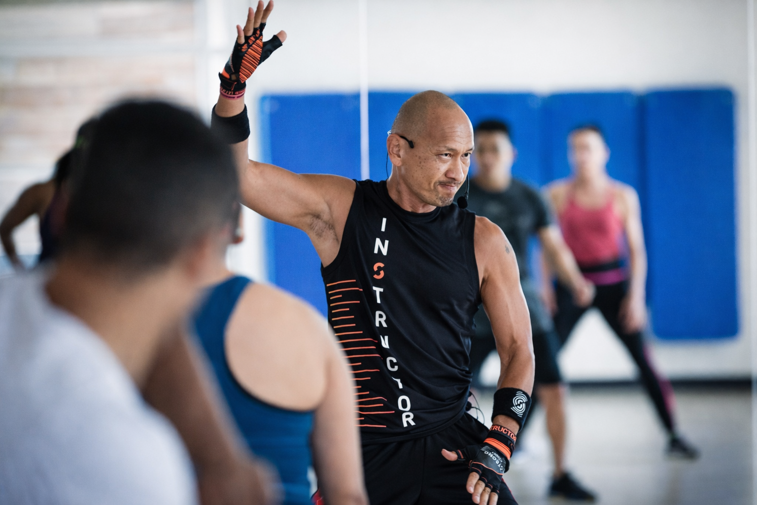 An energetic fitness instructor leads the class with focus and intensity, guiding participants through a dynamic and motivating workout session.
