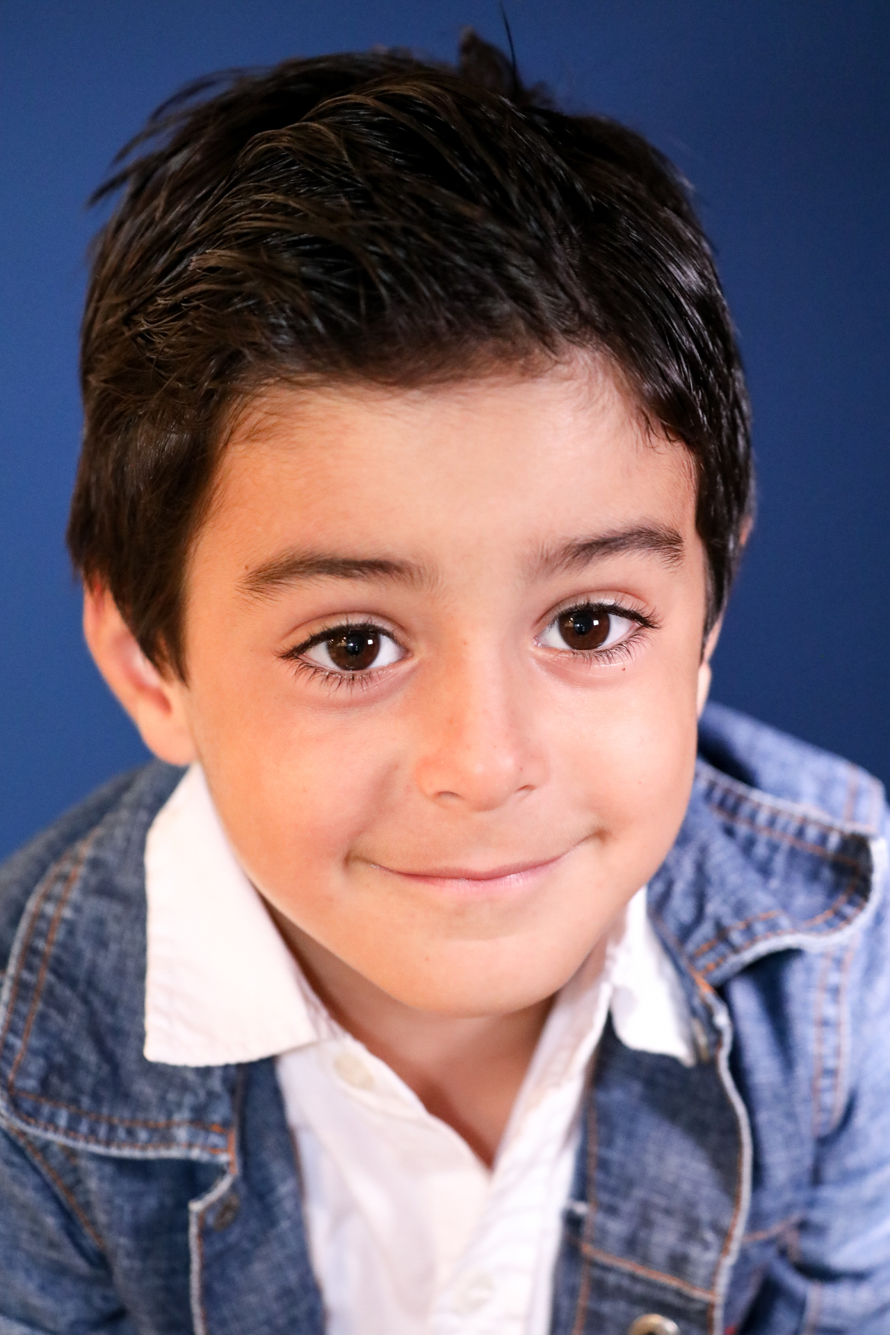 A bright studio portrait capturing youthful energy, warm expression, and a natural smile full of personality.